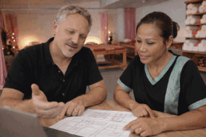 Webdesigner bespreekt website schetsen met klant aan tafel